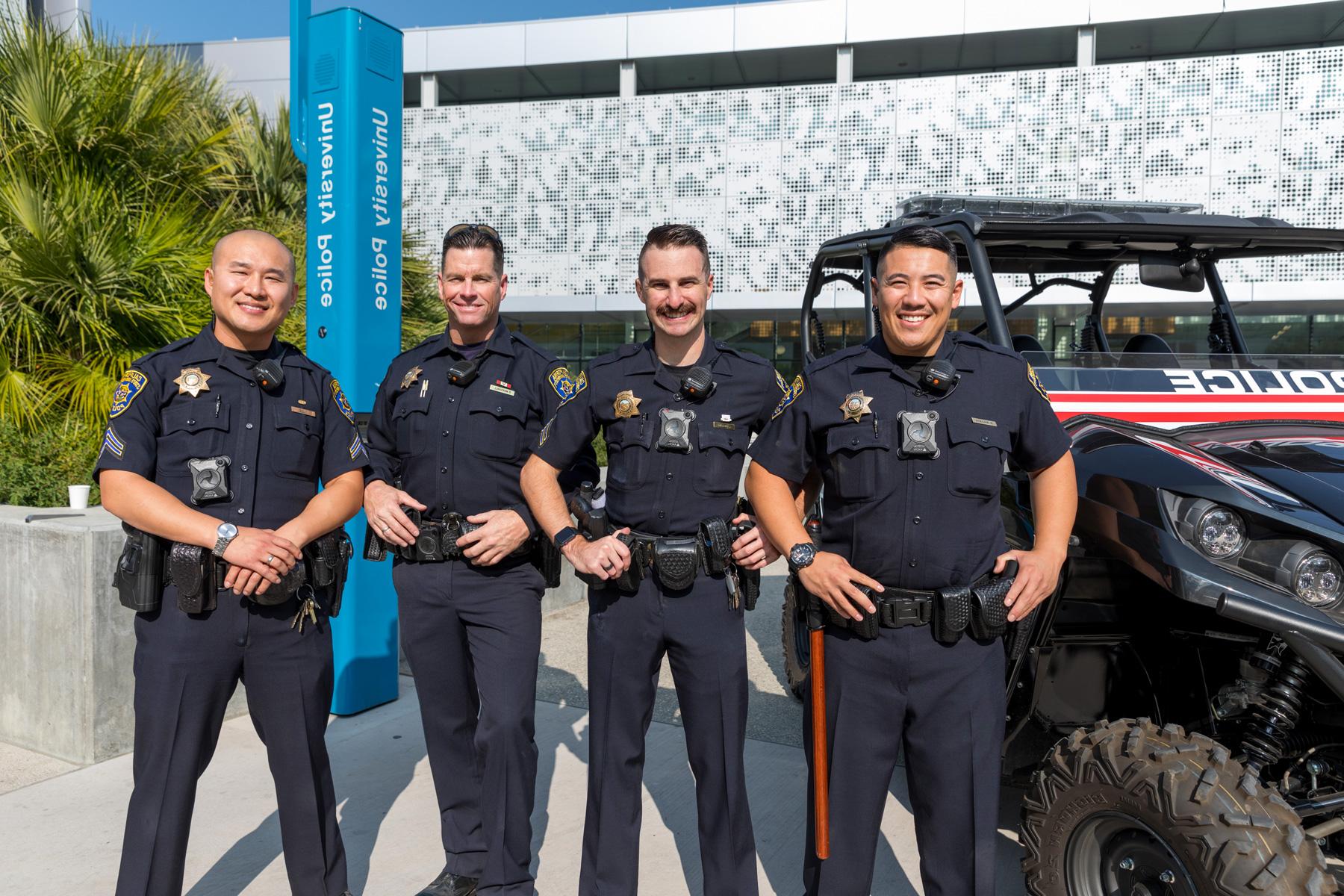 A group of 菠菜网lol正规平台 campus cops pose with a smile on campus.